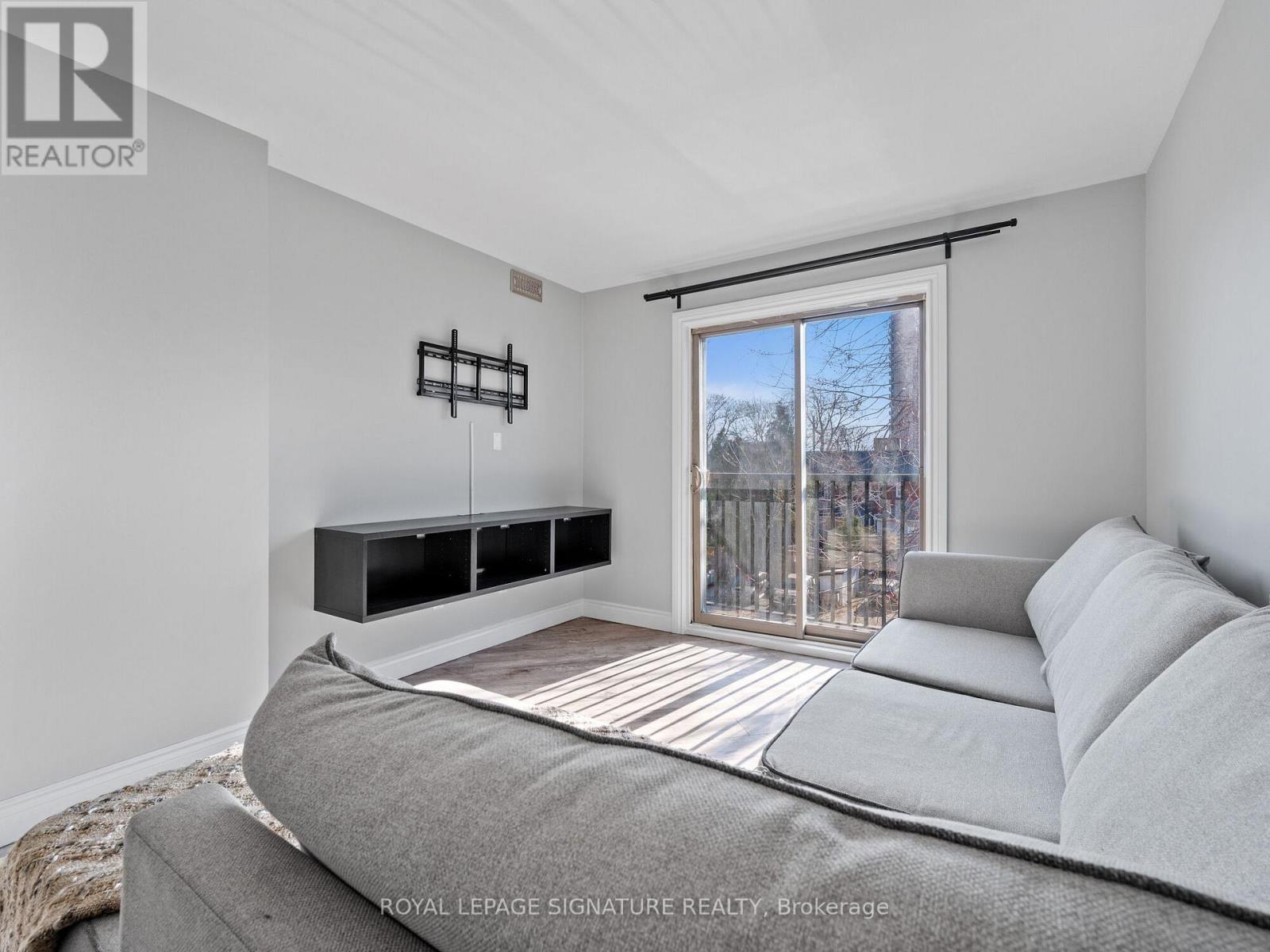 A bedroom with a bed, nightstand, and window with blinds.