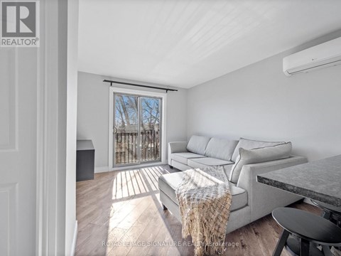 A living room with a couch, a chair, and a table with a blanket on it.