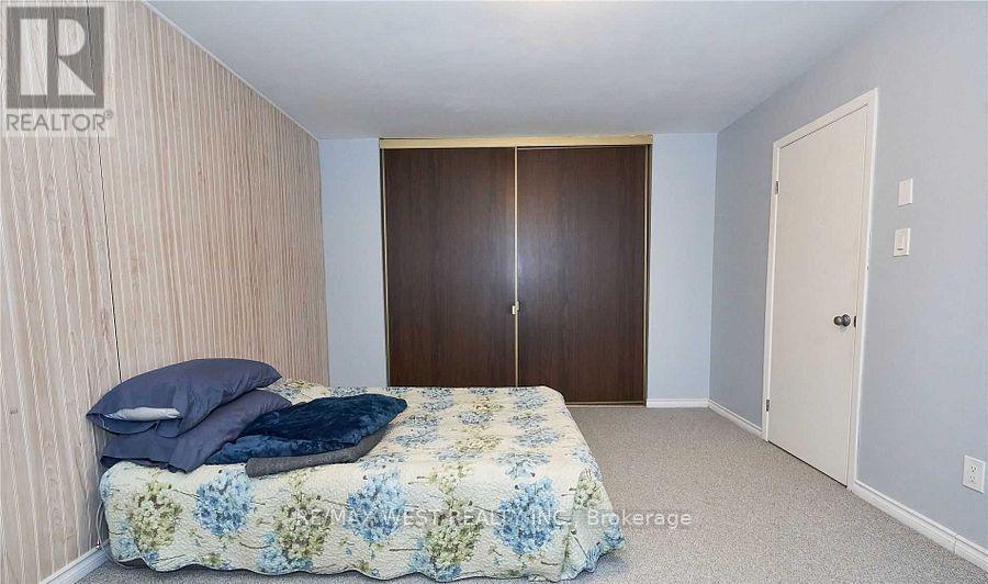 A bedroom with a bed, pillow, and a wooden wardrobe.