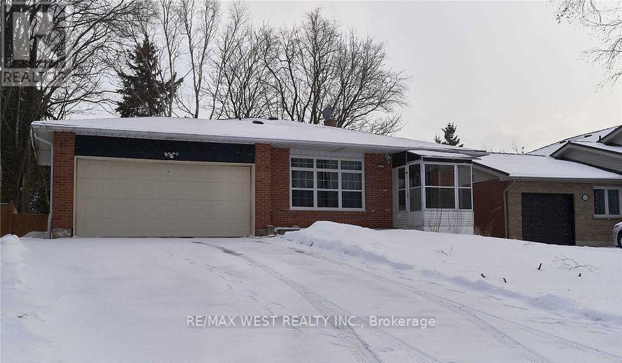 A house with a garage and snow on the ground.