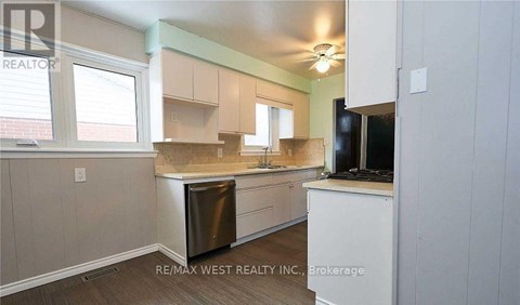 A kitchen with white cabinets and a stainless steel dishwasher.