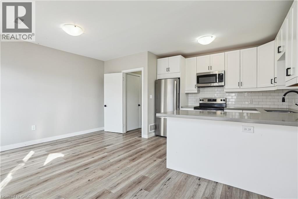 A kitchen with white cabinets and a wooden floor.