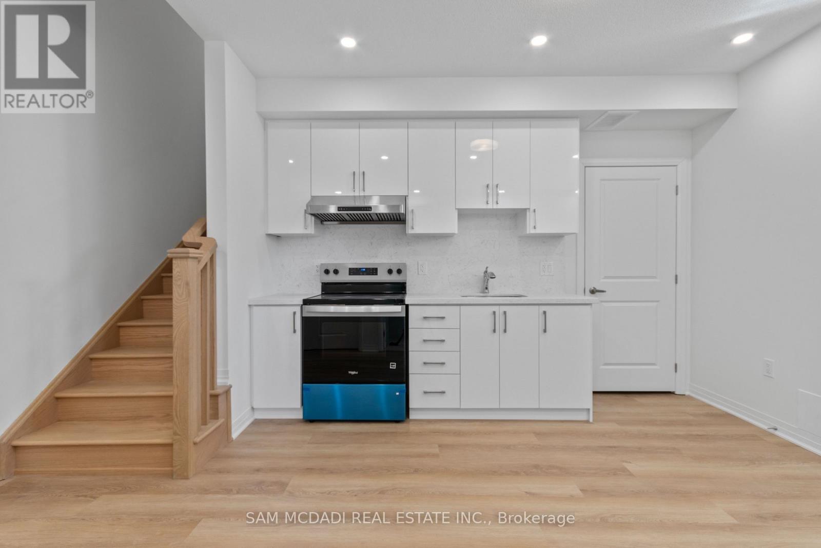 A kitchen with white cabinets and a blue dishwasher.