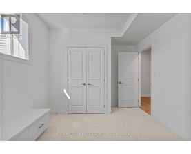 A white bedroom with two doors and a window.