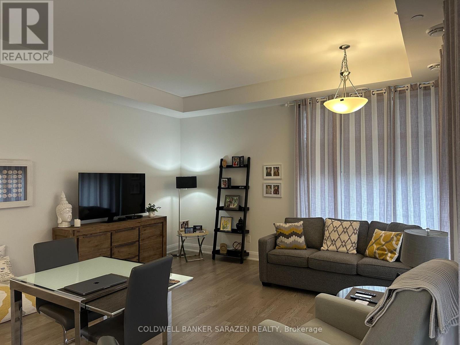 A modern living room with a grey sofa and a glass table.