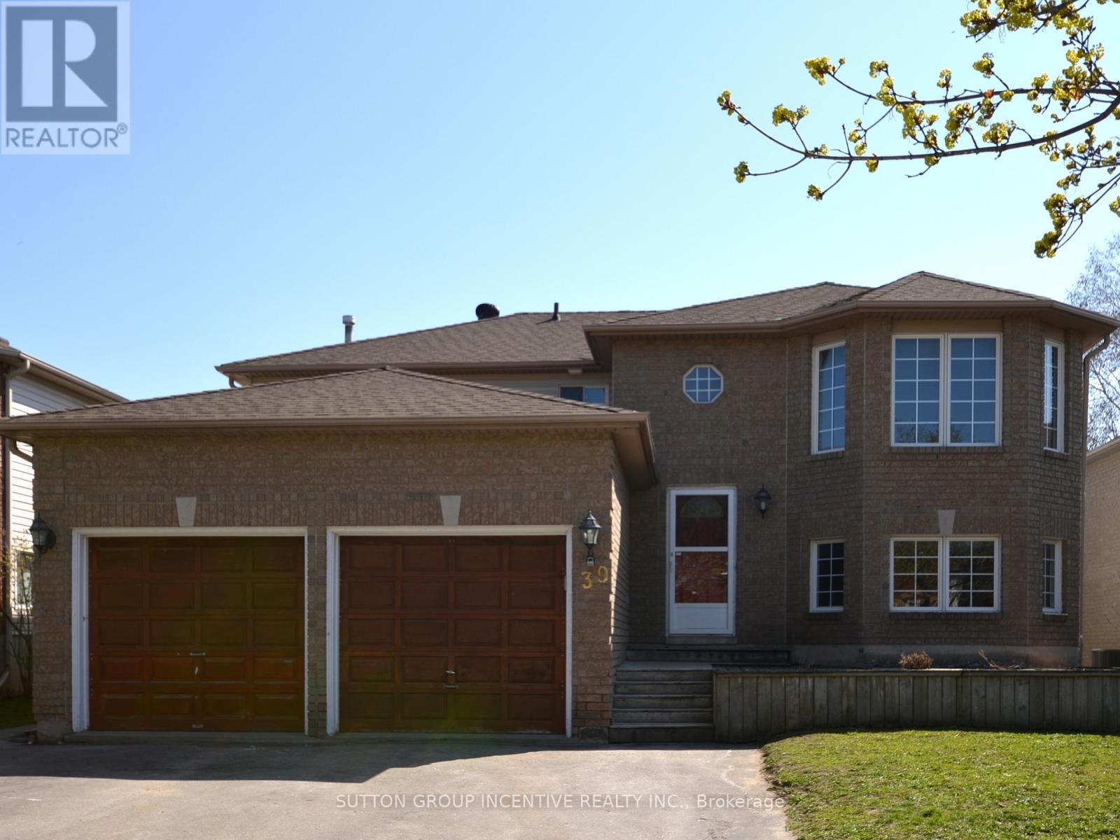 A house with a brown roof and two garage doors is for sale.