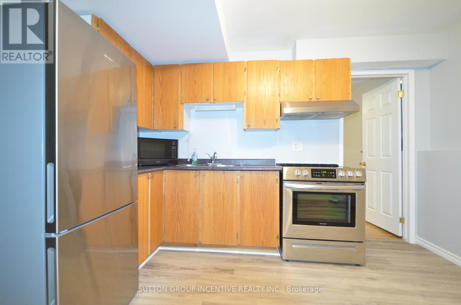 A kitchen with wooden cabinets and stainless steel appliances.
