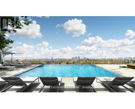 A pool with lounge chairs and a city skyline in the background.