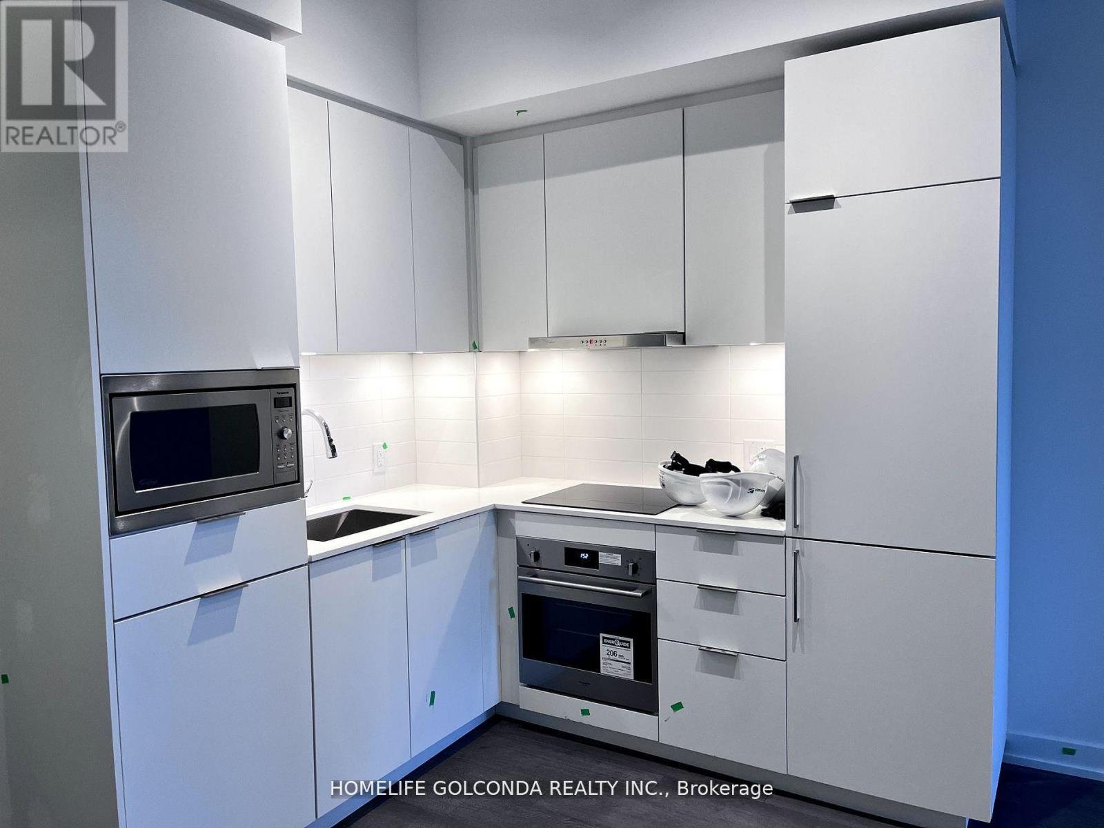 A kitchen with white cabinets and appliances is on the market.