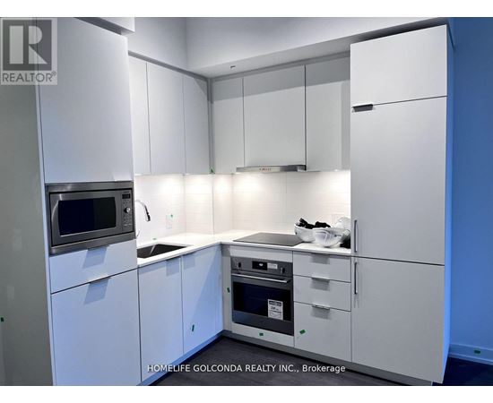 A kitchen with white cabinets and appliances is on the market.