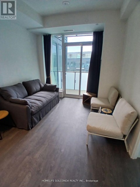 A living room with a black couch and a white chair.