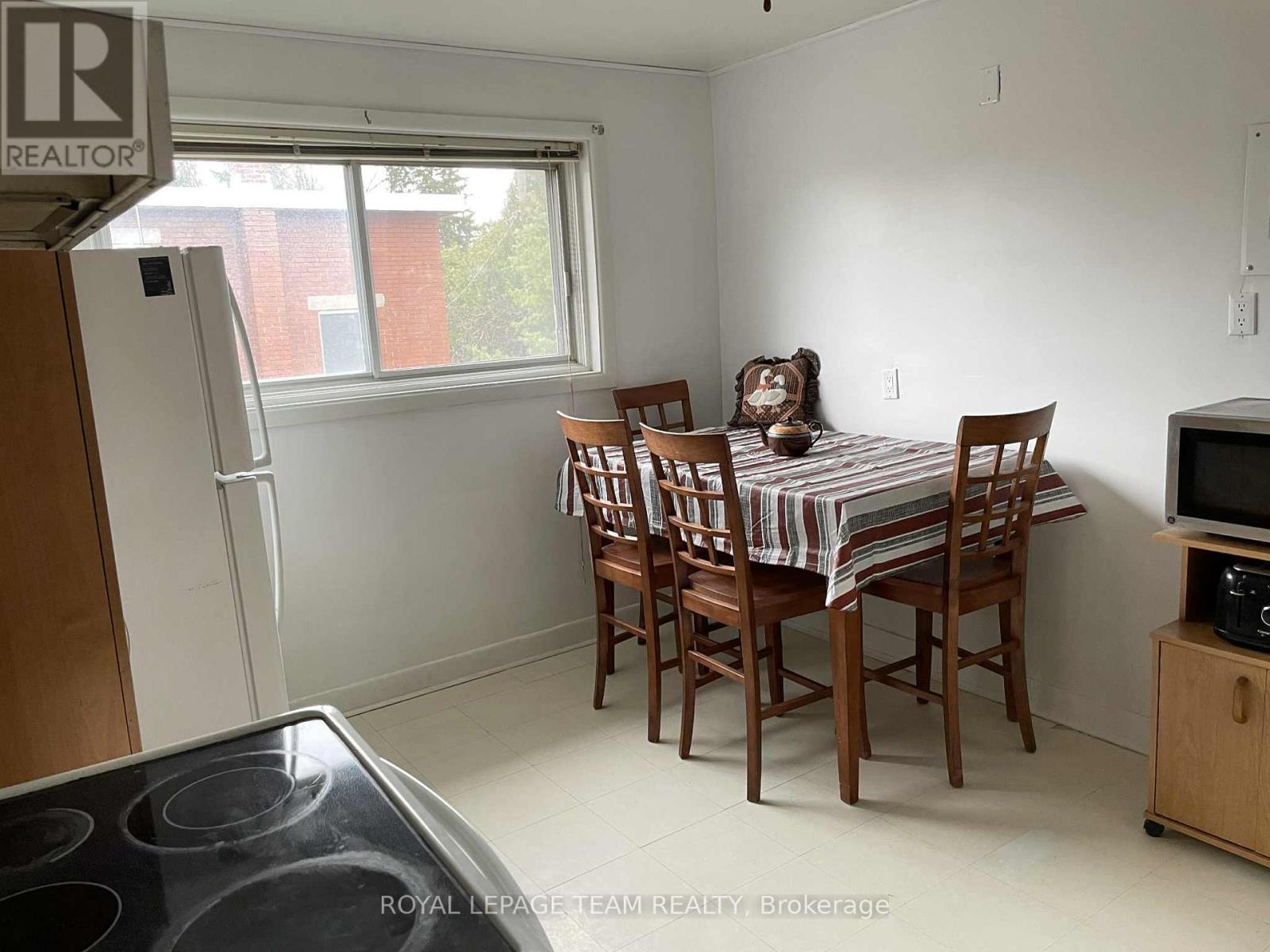 A kitchen with a table and chairs in front of a window.