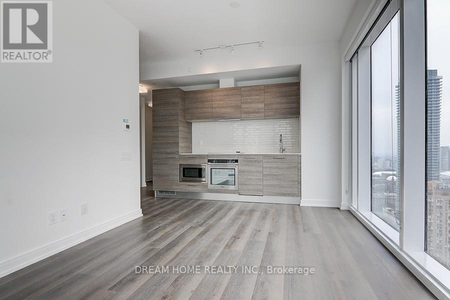 A modern kitchen with wooden cabinets and a large window.