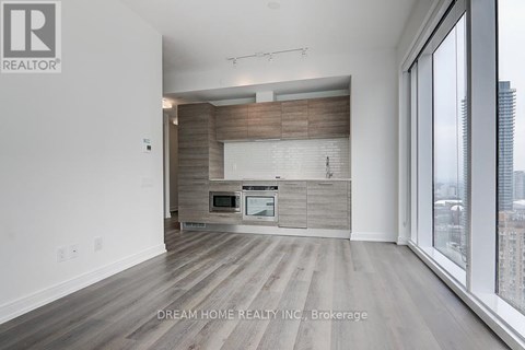A modern kitchen with wooden cabinets and a large window.