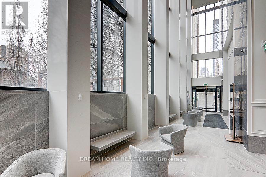 A modern interior space with a marble floor and grey furniture.