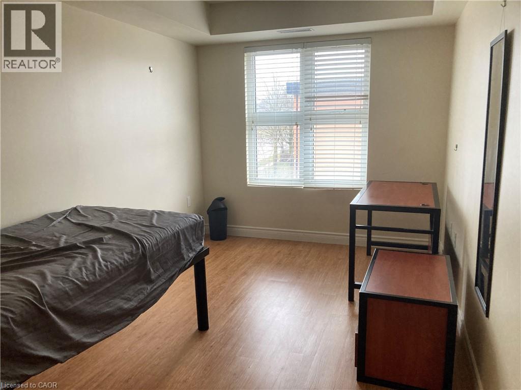 A bedroom with a bed, nightstand, and window.
