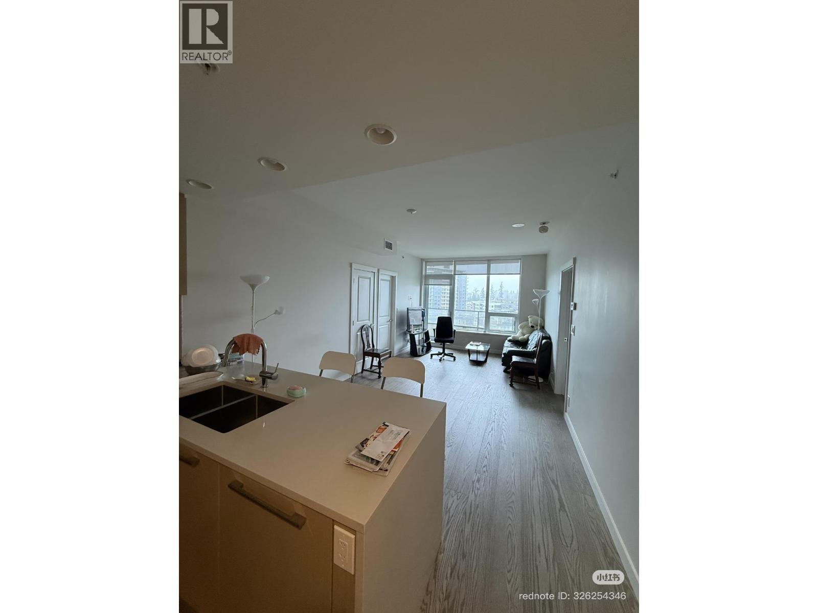 A kitchen with a sink, a dining table with chairs, and a living room with a couch and a coffee table.