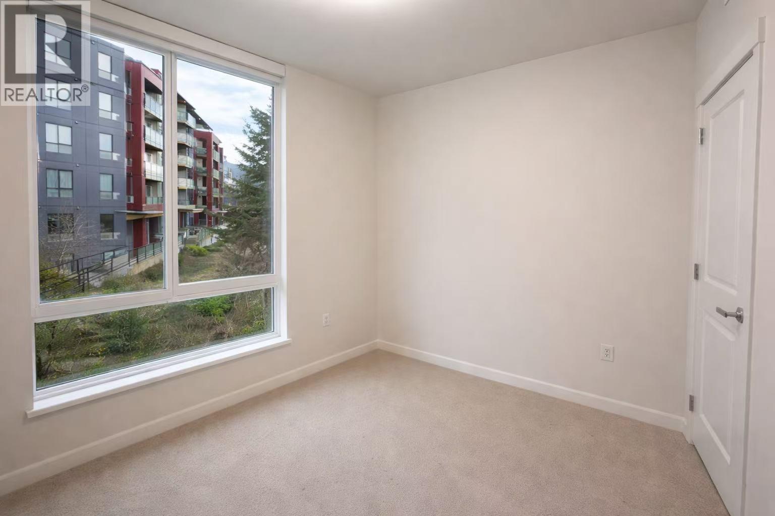 A bedroom with a bed, a nightstand, and a lamp.