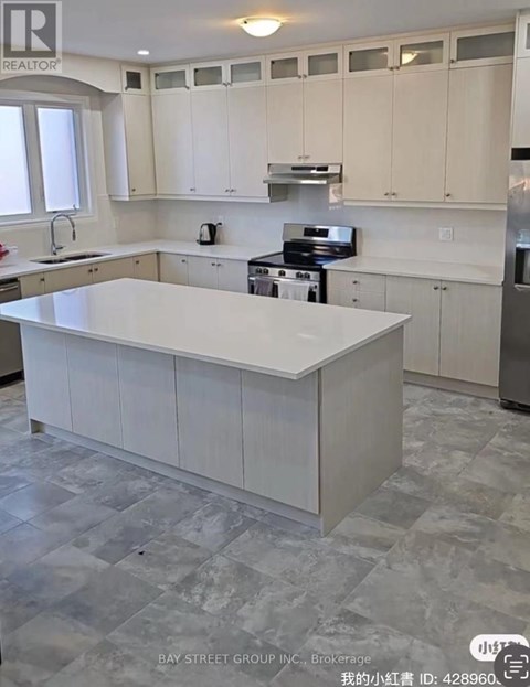 A kitchen with white cabinets and a large island.