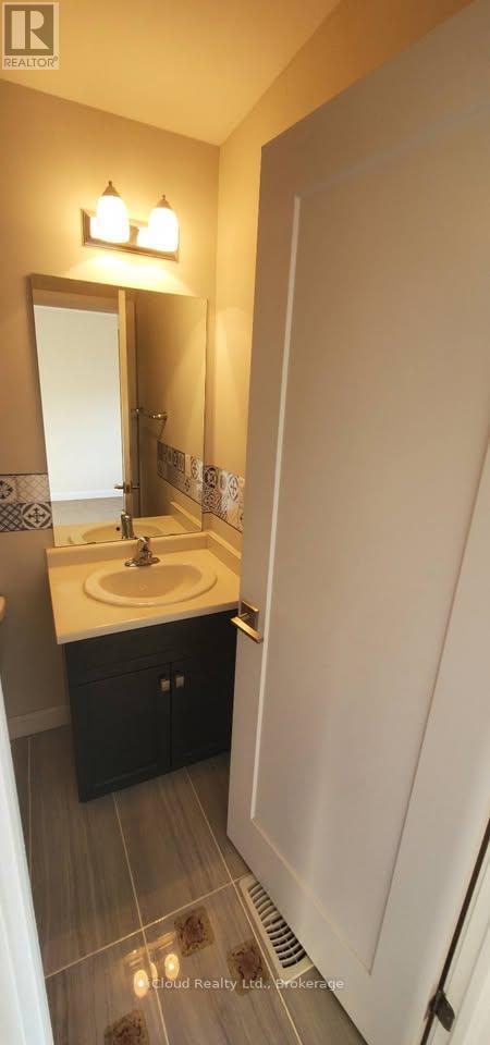 A bathroom with a sink, mirror, and tiled floor.