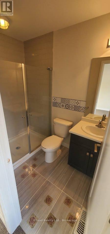 A bathroom with a toilet, sink, and shower.