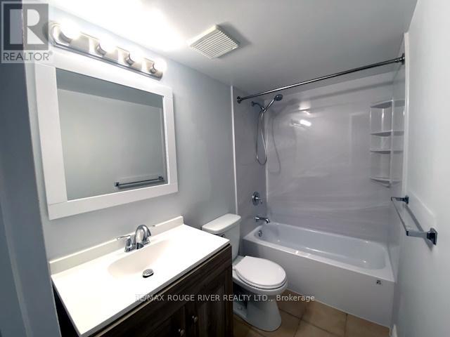 A bathroom with a white sink, toilet, and bathtub.