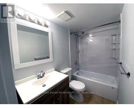 A bathroom with a white sink, toilet, and bathtub.