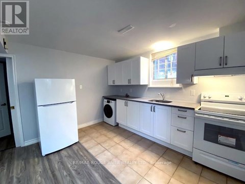 A kitchen with white appliances and cabinets.