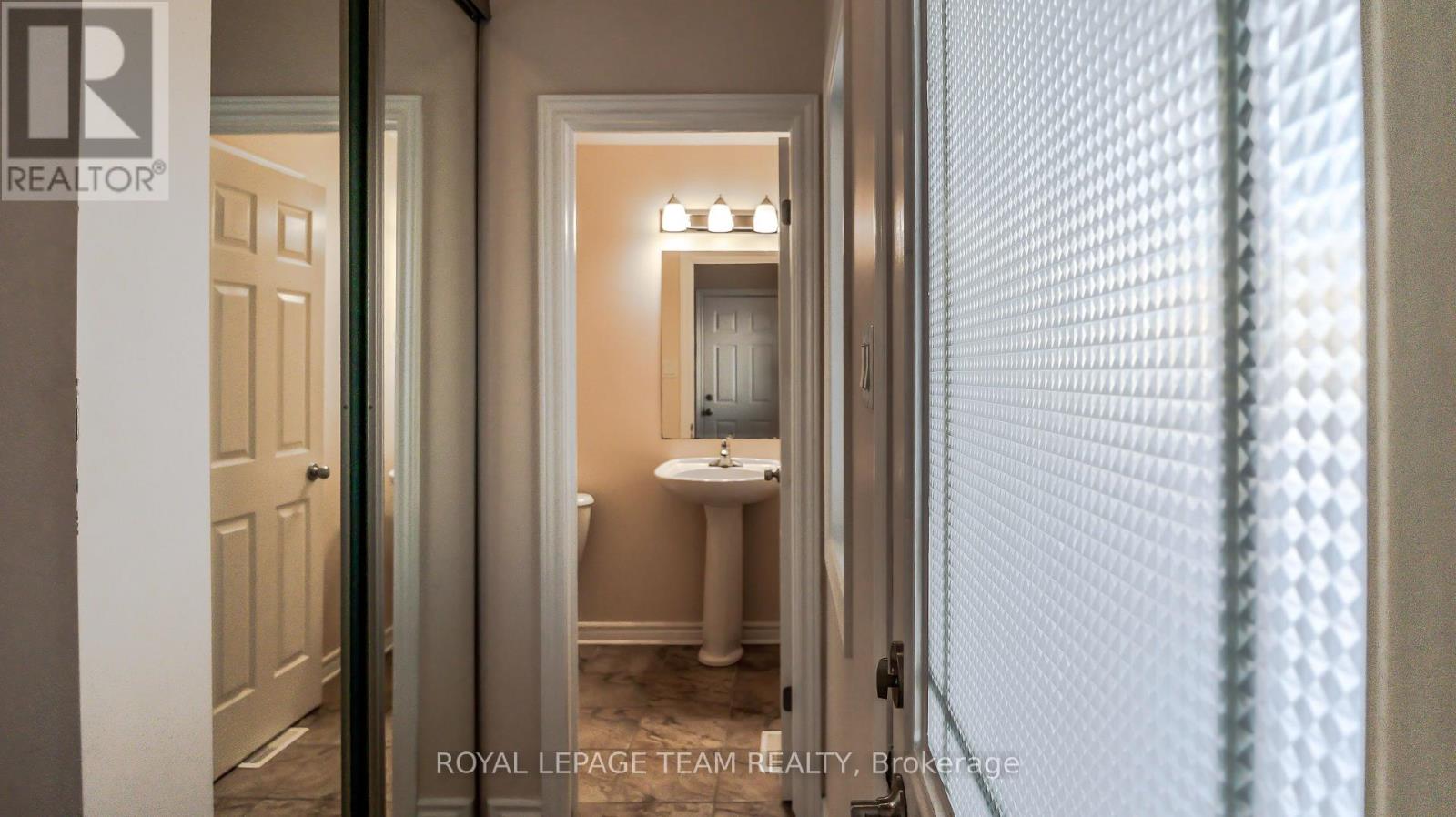 A hallway with a white door and a white bathroom visible through the door.