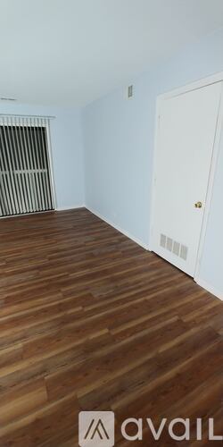 A room with wooden flooring and a white door.