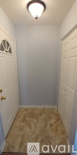 A hallway with a tiled floor and white walls.