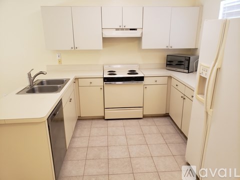 A kitchen with white cabinets and appliances.