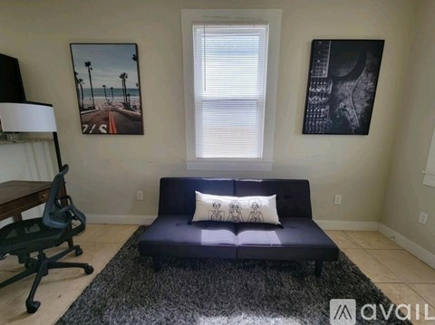 A living room with a blue couch and a black and white rug.