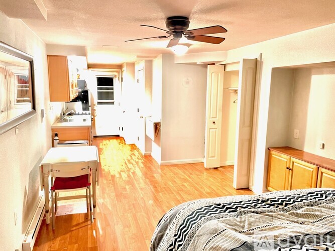 A bedroom with a bed, table and chairs is shown.