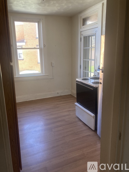 A bedroom with a bed, desk, and window.