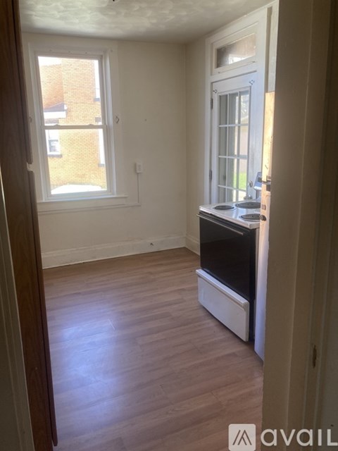 A bedroom with a bed, desk, and window.