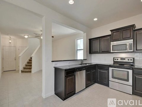 A kitchen with black cabinets and a white stove top oven.