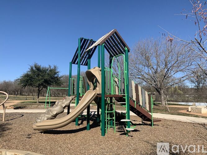 A playground with a green slide and a brown slide.