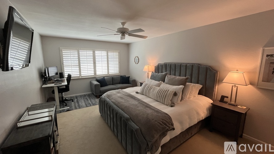 A bedroom with a large bed and a ceiling fan.
