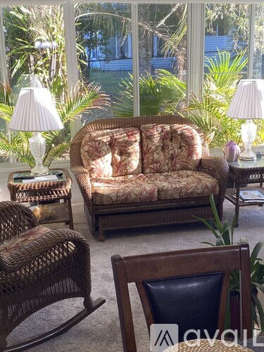 A living room with a sofa, rocking chair, and two tables with lamps.