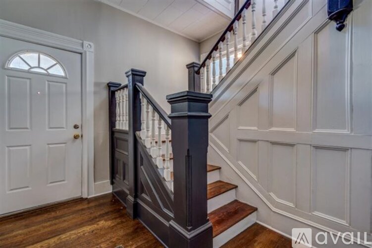 A staircase with a wooden handrail and white steps.