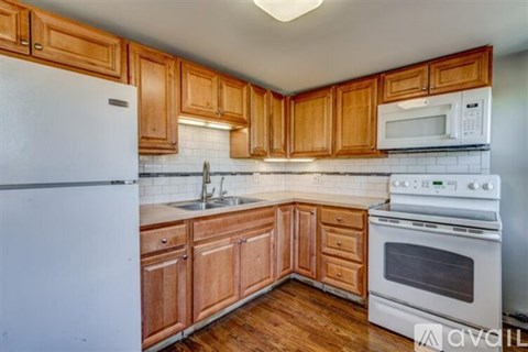 A kitchen with wooden cabinets and white appliances.