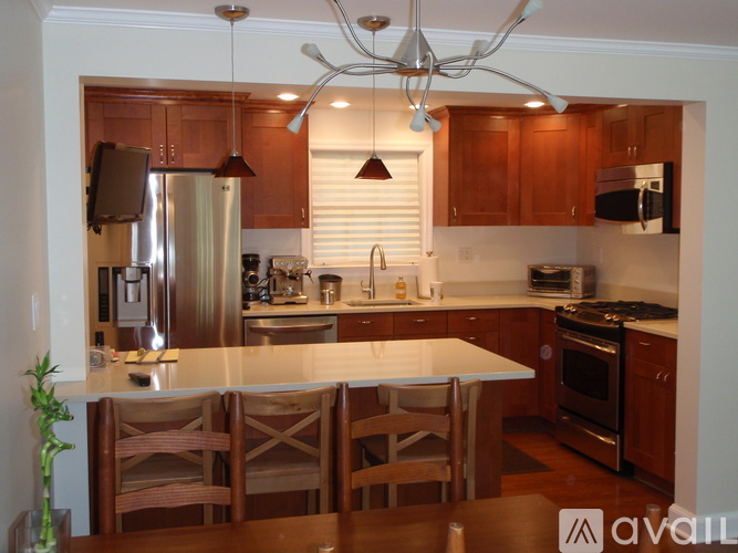 A kitchen with wooden cabinets and a white island.