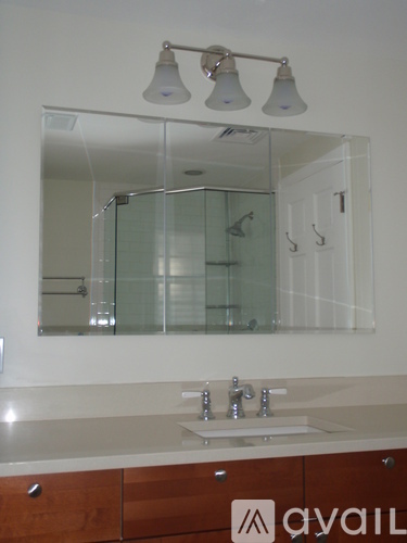 A bathroom with a sink, mirror, and lights.