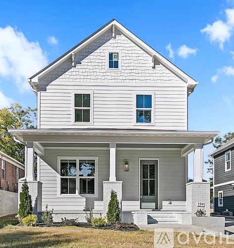 A white two-story house with a front porch.