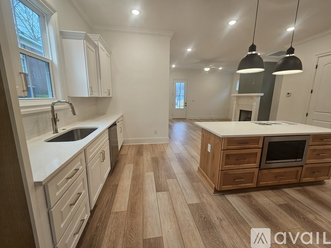 A kitchen with wooden floors and white cabinets is available for rent.