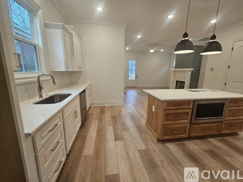 A kitchen with wooden floors and white cabinets is available for rent.