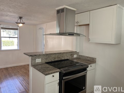 A kitchen with a granite countertop and white cabinets.