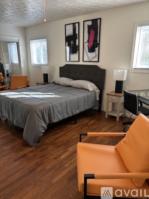A bedroom with a bed, desk, and chair.