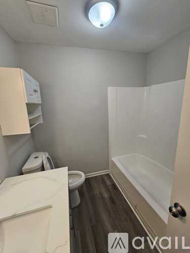 A bathroom with a toilet, sink, and bathtub.